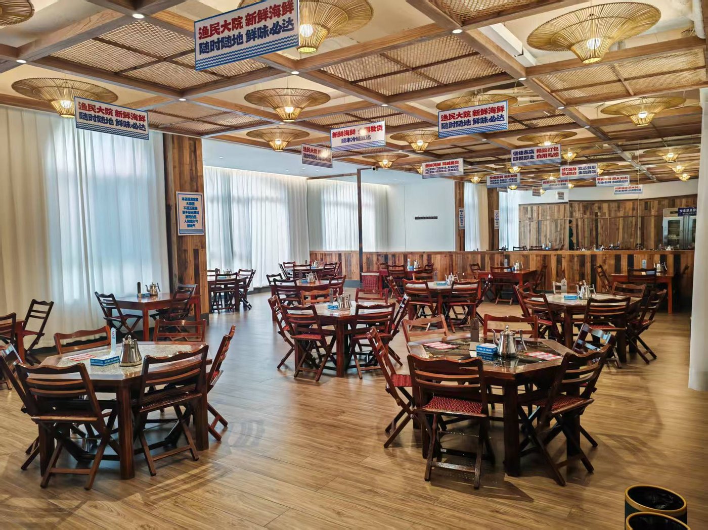 渔民大院·海鲜大排档寿光店宽敞大厅散台与圆桌餐位实拍